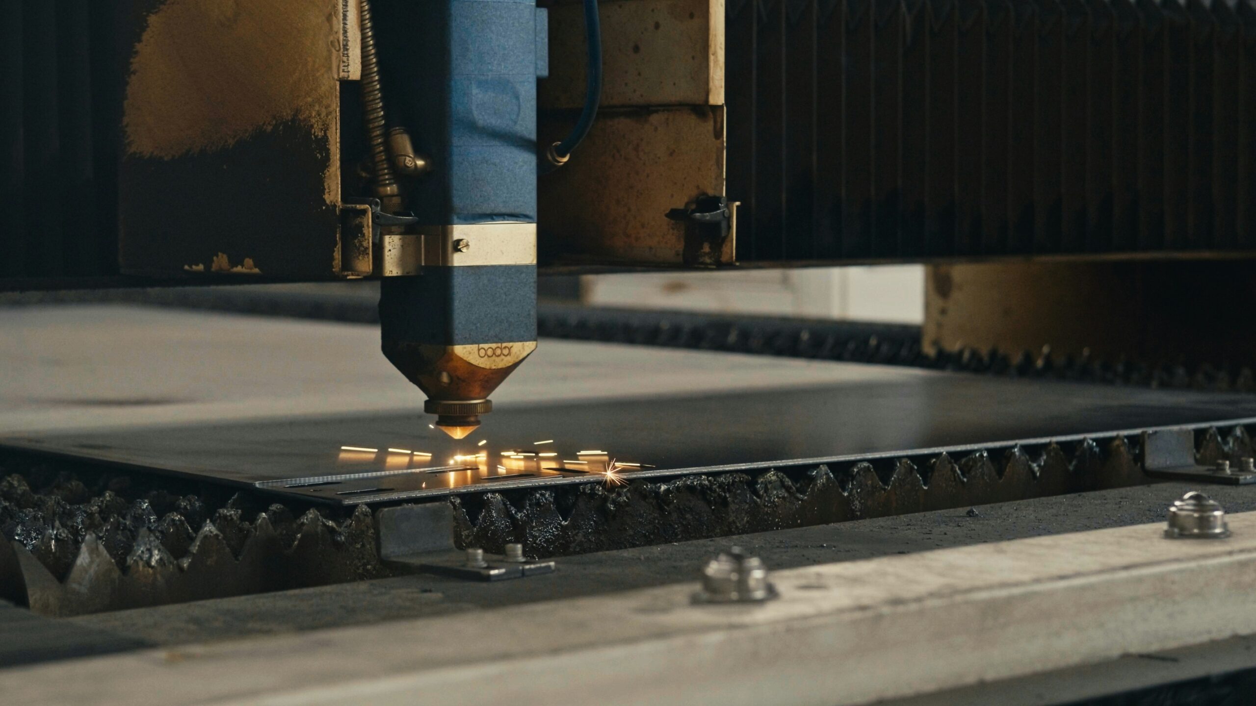 Máquina de corte láser trabajando sobre una pieza en el taller