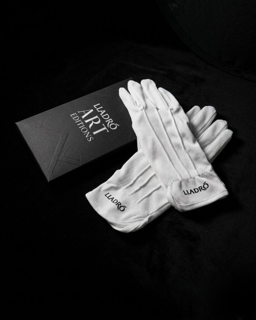 Guantes blancos de algodón con el logotipo del cliente marcado, junto a su funda negra