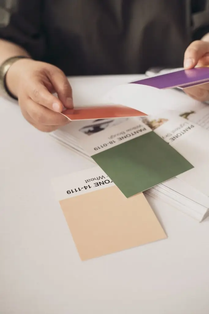 Manos eligiendo muestras de color Pantone para ajustar el tono de un marcaje