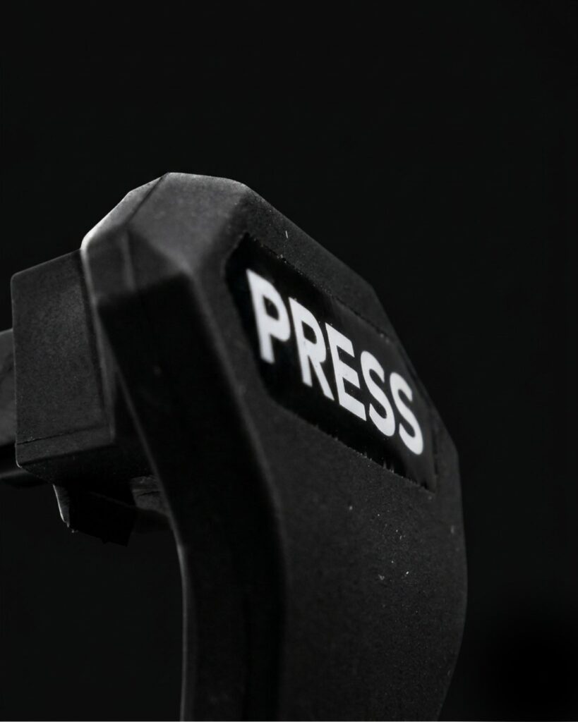 Marcaje técnico industrial: pulsador de plástico negro con la indicación PRESS serigrafiada en blanco