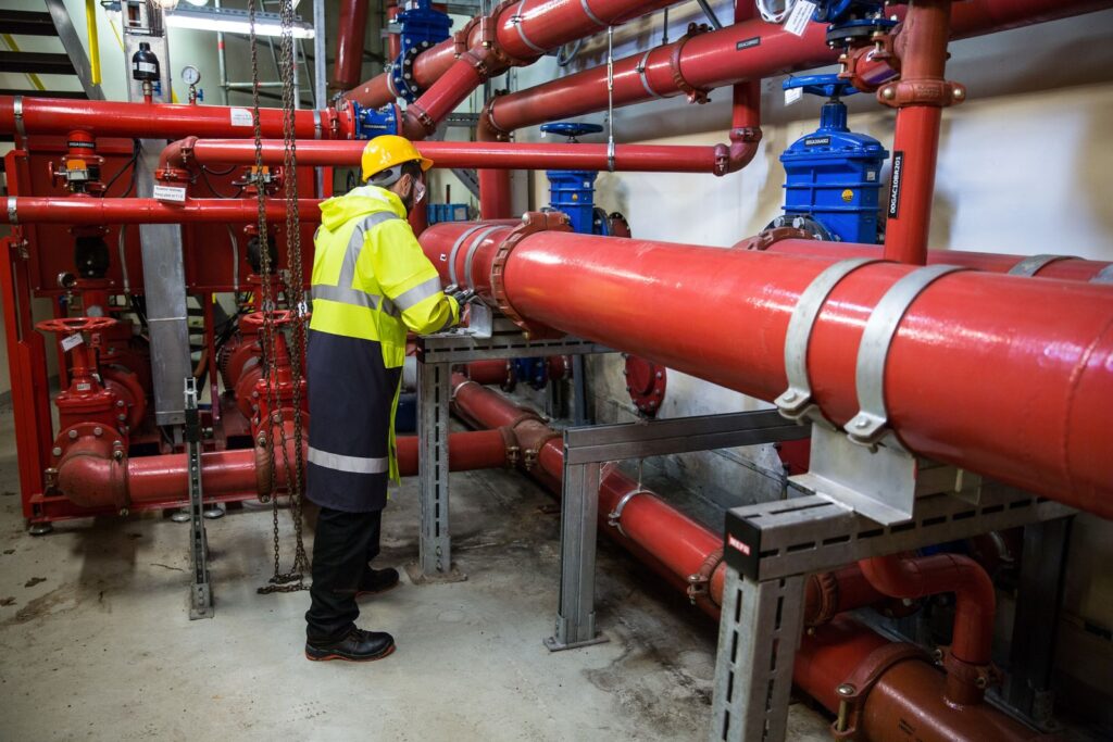 Trabajador con parka de alta visibilidad y bandas reflectantes en una instalación industrial