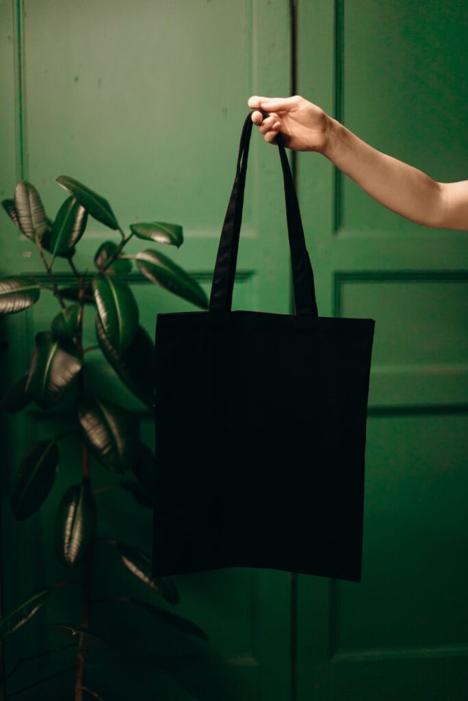 Persona sujetando una bolsa tote de algodón negra