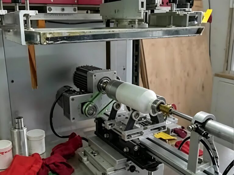 Máquina de serigrafía cilíndrica con un envase montado entre puntos bajo la pantalla de impresión